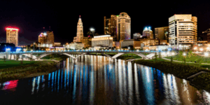 Columbus Ohio skyline at night with city lights reflecting on the river